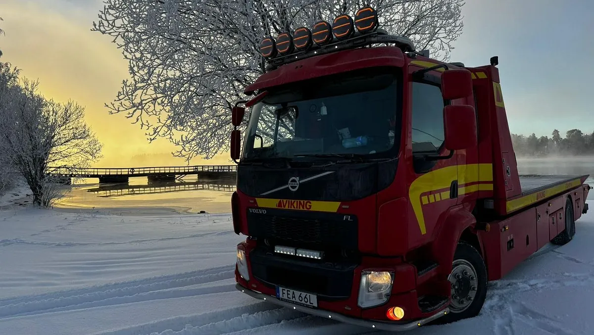 Bärgningsbil stående väntande på utryckning vid en sjö vintertid